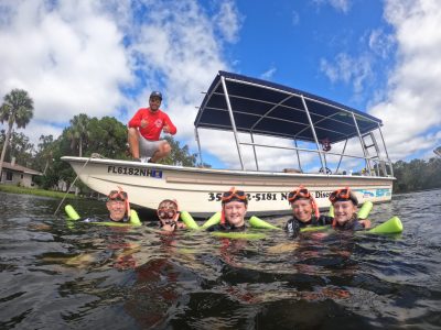 a group of people in a small boat in a body of water